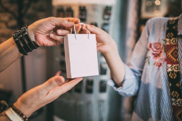 Une vendeur tend un paquet à un client
